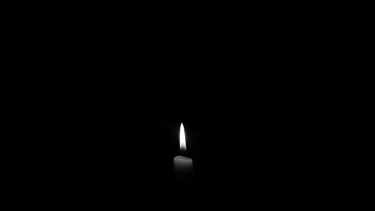 A lit candle in the dark — candles are the most common cause of soot on walls and ceilings