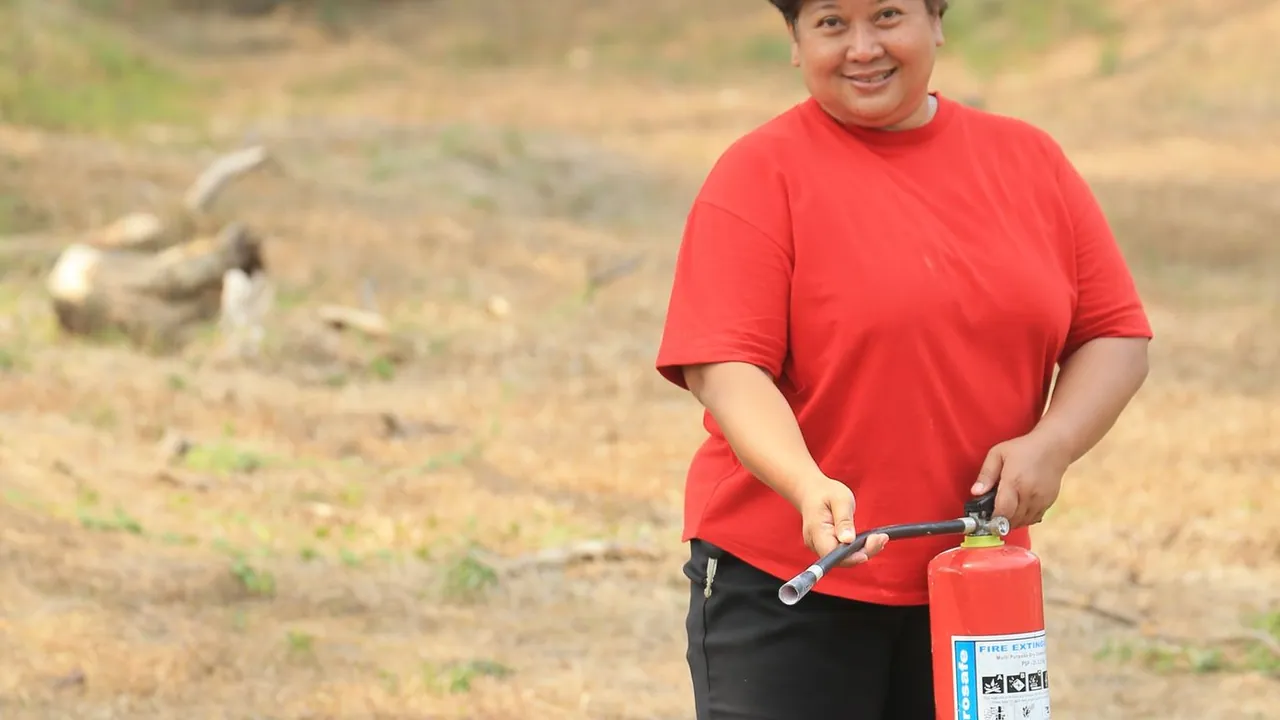Person holding a fire extinguisher — a Class K or B extinguisher is the correct backup for a kitchen grease fire
