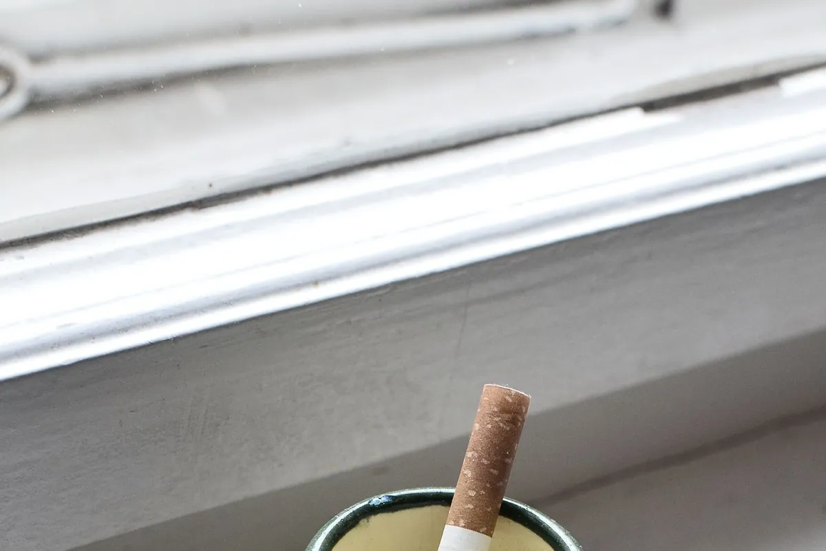 A cigarette on a windowsill — the tobacco residue and odor we remove from homes and condos