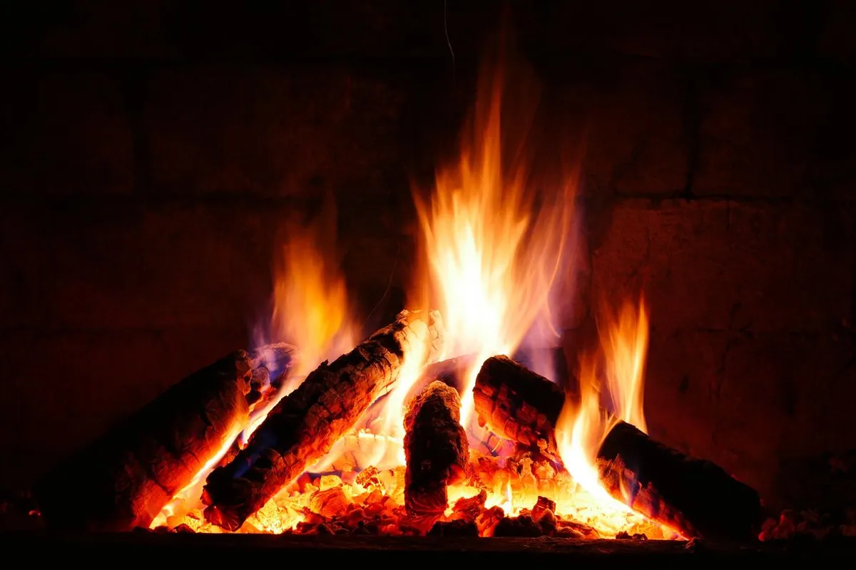 Burning logs in a fireplace — a common source of soot on surrounding brick and walls
