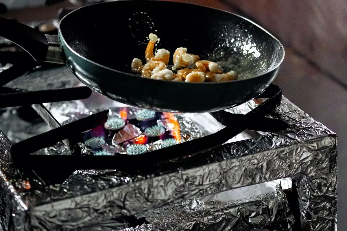 A pan on a hot stovetop — the source of greasy soot from a kitchen grease fire