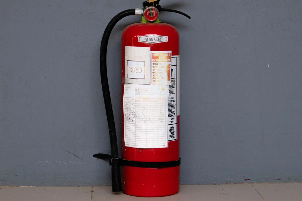 Red fire extinguisher on a wall — kitchen fire cleanup for Boca Raton homes